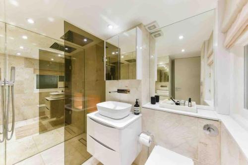 a bathroom with a toilet and a sink and a shower at Luxury Modern Apartment in London