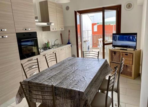 une cuisine avec une table et des chaises ainsi qu'une télévision dans l'établissement TORTORETO LIDO - Vista Mare-appartamento a mt100 dal mare, à Tortoreto Lido
