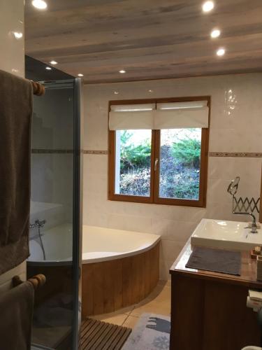 une salle de bain avec une baignoire et un lavabo dans l'établissement Le Cerf d'Argent, à Saint-Andéol