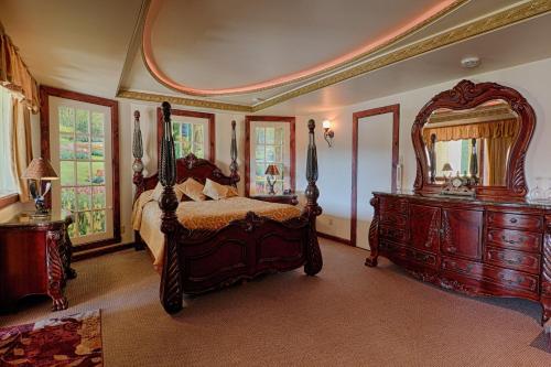a bedroom with a bed and a large mirror at Auberge Aux Nuits de Rêve in Sainte-Agathe-des-Monts