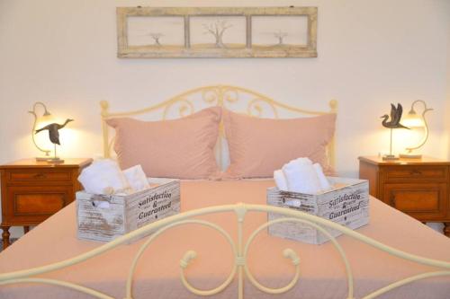 a bed with two boxes on it with two lamps at L'olivier Milos in Plaka Milou