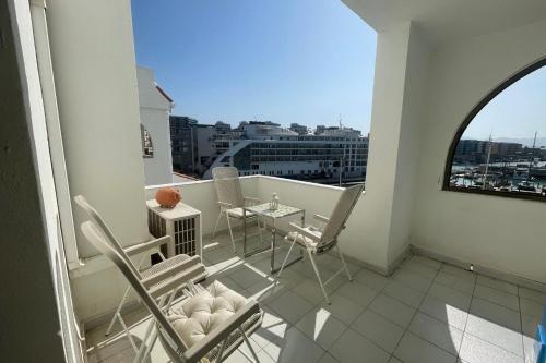 einen Balkon mit Stühlen, einem Tisch und einem Fenster in der Unterkunft Neptune Suite-Hosted by Sweetstay in Gibraltar