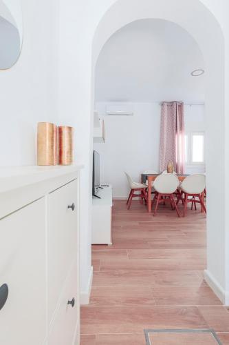 a kitchen and dining room with white cabinets and a wooden floor at Camas casa a 5 min de Sevilla con piscina in Camas