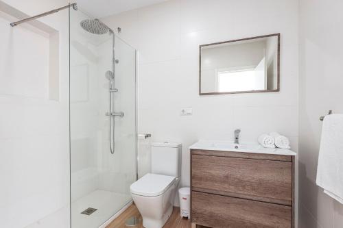 a white bathroom with a toilet and a shower at Camas casa a 5 min de Sevilla con piscina in Camas