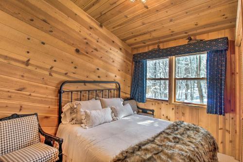 ein Schlafzimmer mit einem Bett und einem Fenster in einem Blockhaus in der Unterkunft Pinetop Cabin with Private Patio on Eighth Green! in Indian Pine