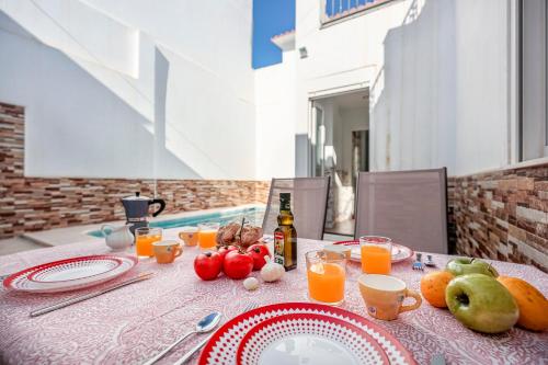 a table with fruit and juice on top of it at Camas casa a 5 min de Sevilla con piscina in Camas