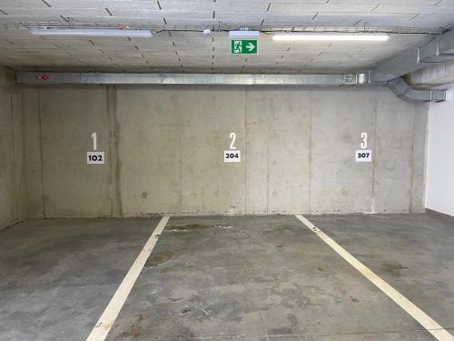 an empty parking lot with numbered signs on the wall at KLINOVEC APARTMENTS LUXURY in Loučná pod Klínovcem