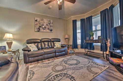 a living room with a leather couch and a television at Niagara Falls Townhome Near Wineries! in Niagara Falls