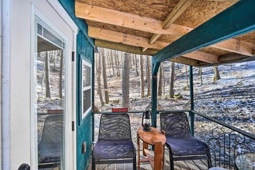 a porch with two chairs and a table at Hiking Trails On-Site Cozy Falls Brook Cabin in Williamsville Station