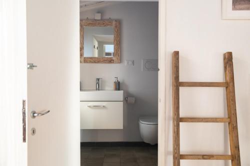 a bathroom with a toilet and a mirror and a ladder at Loft nel borgo in Bracciano