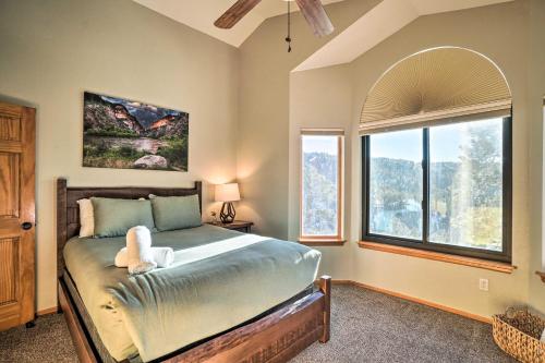 a bedroom with a bed and a large window at Expansive Evergreen Home with Hot Tub and Deck! in Evergreen