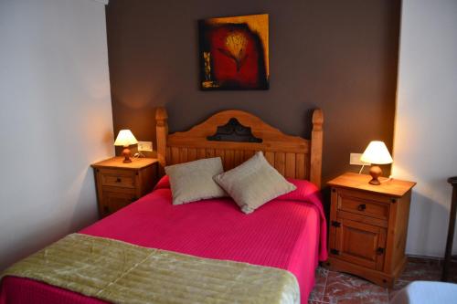 - une chambre avec un lit rouge et 2 tables de chevet dans l'établissement LA CAÑADA, à Alcalá del Júcar
