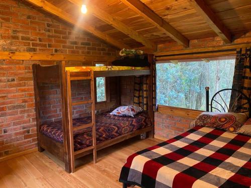 a room with bunk beds in a brick wall at Casa de campo rústica en Cuenca in Cuenca