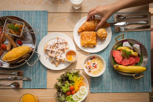 a wooden table with plates of food on it at Holiday Inn Resort Samui Bophut Beach by IHG in Bophut 