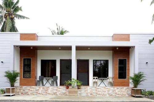 Ein Haus mit einer weißen Fassade und einer Terrasse in der Unterkunft Lucas Transient House in Looc