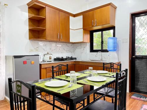 eine Küche mit einem Tisch mit Stühlen und einem Kühlschrank in der Unterkunft Lucas Transient House in Looc
