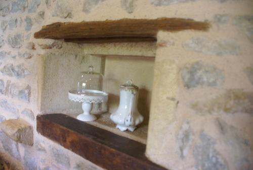 a stone wall with a white vase on a shelf at Chambre D' Hotes Des Collines in Amanzé