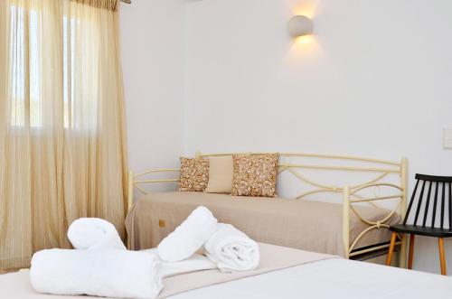 um quarto de hotel com duas camas e toalhas em Louros rooms em Koufonisia