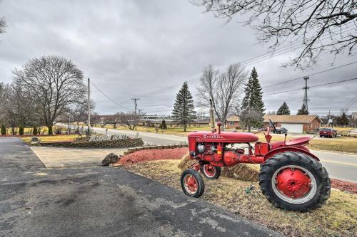 a red tractor sitting on the side of a road at Pet-Friendly Bartlett Farmhouse with Deck! in Bartlett