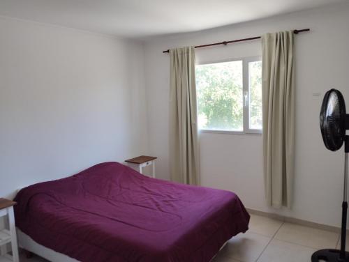 a bedroom with a purple bed and a window at El Descanso 2 in Tandil