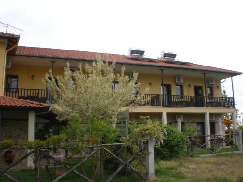 a yellow house with a fence in front of it at Olympia Guesthouse in Vergina