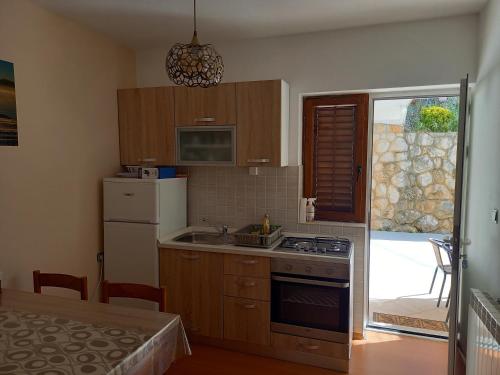 een keuken met een wastafel en een fornuis top oven bij Oliva in Rab