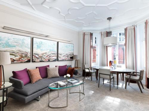 a living room with a couch and a table at The Athenaeum Hotel & Residences in London