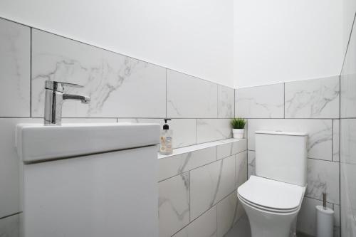 biała łazienka z toaletą i umywalką w obiekcie Stunning Duplex near Canary Wharf & O2 & City Views w Londynie