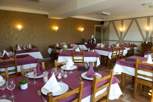 a dining room with purple tables and chairs at Auberge Saint-Martin in Orchimont