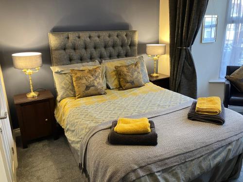 a bedroom with a bed with yellow towels on it at THE PROMENADE SUITE - 2 min walk to the lovely beach front promernade of llandudno in Llandudno