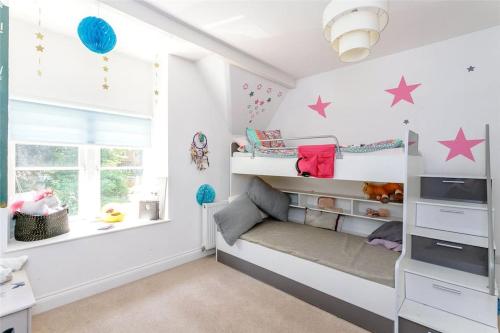 Habitación infantil con literas y estrellas en la pared en Northampton Modern Oasis - Spacious & Stylish en Northampton