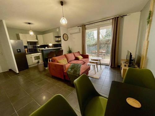 a living room with a couch and a kitchen at La nature aux portes de Toulouse in Pinsaguel
