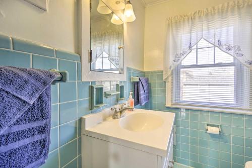 a blue tiled bathroom with a sink and a mirror at Allenhurst Abode with Porch and Central Location! 