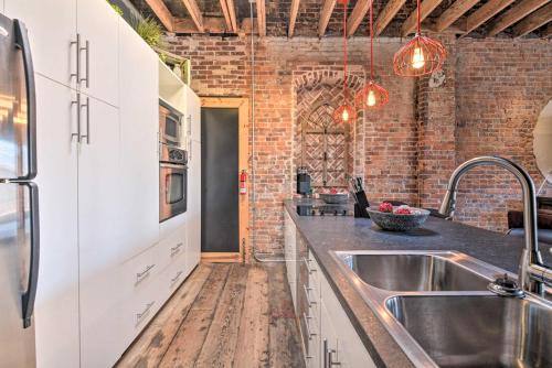 a kitchen with a sink and a brick wall at Upscale Loft in the Heart of Dtwn Springfield in Springfield