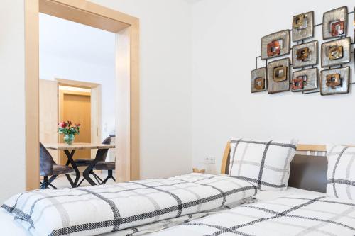 two beds in a room with a table and a mirror at Haus Raich in Arzl im Pitztal