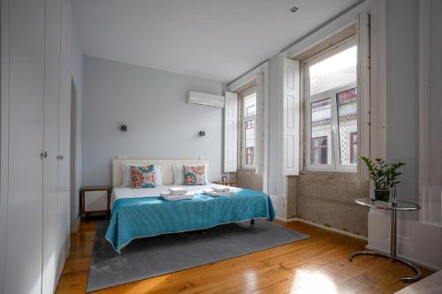a bedroom with a bed with a blue blanket at Oporto Trendy Apartments in Porto