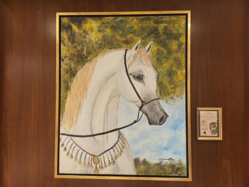 a painting of a white horse hanging on a wall at Velar Inn Hotel in Taif