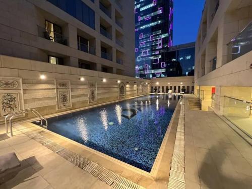 - une piscine au milieu d'un bâtiment la nuit dans l'établissement Nice cozy studio in Damac Tower Amman 1104, à Amman