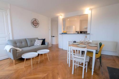 un salon avec un canapé, une table et des chaises dans l'établissement La Place Gourmande, à Mâcon