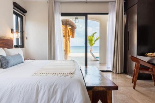 a bedroom with a bed and a view of the ocean at Bella Villa in Tulum