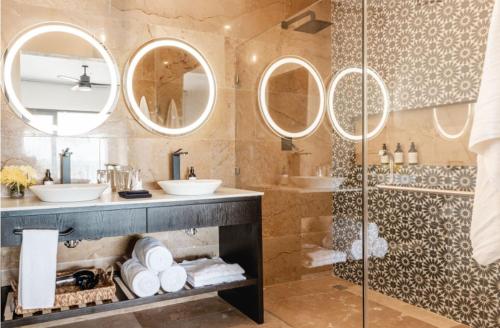 a bathroom with two sinks and a shower with mirrors at Bella Villa in Tulum