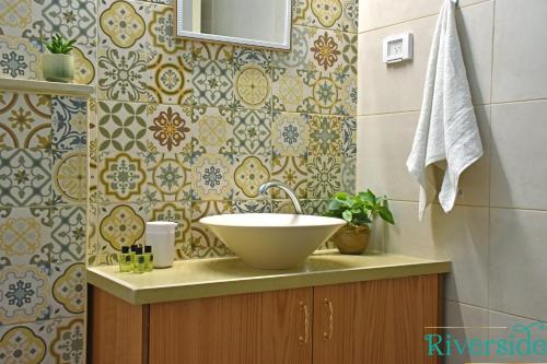 a bathroom with a sink and a tile wall at Riverside in Majdal Shams