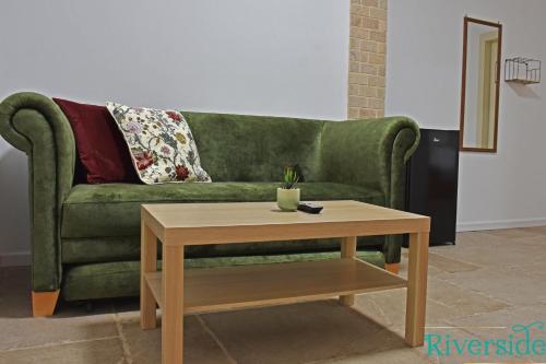 a green couch with a coffee table in a living room at Riverside in Majdal Shams