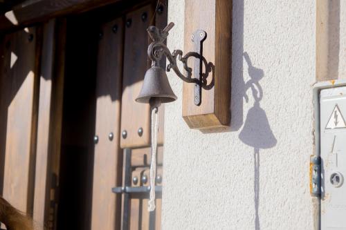 a bell hanging on the side of a building at CASA RURAL VEGASAN in Santa Colomba de la Vega