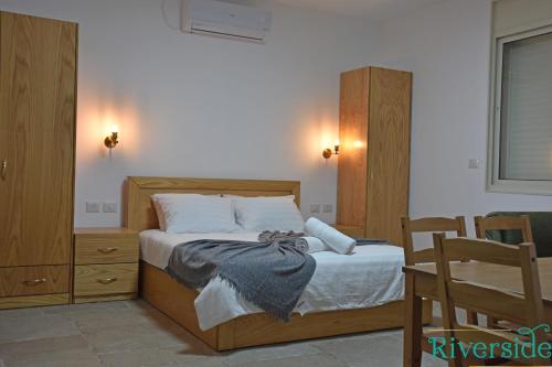 1 dormitorio con 1 cama con cabecero de madera en Riverside en Majdal Shams
