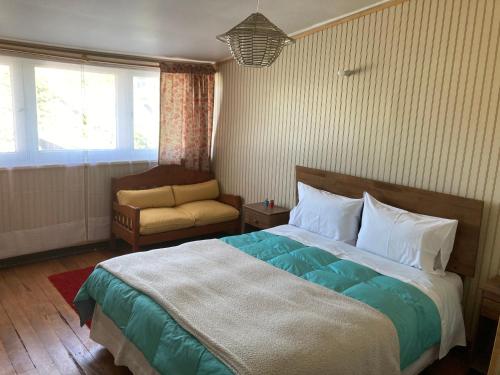 1 dormitorio con 1 cama, 1 silla y 1 ventana en Hostal Argentina Osorno en Osorno