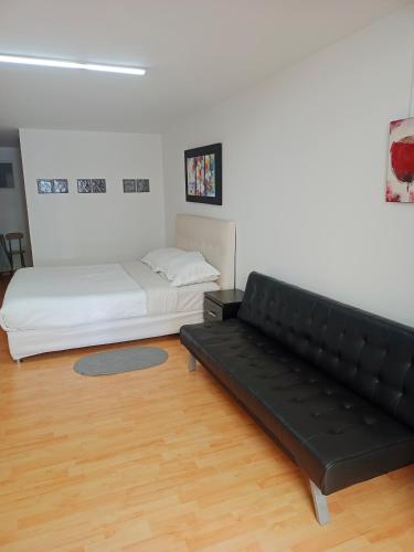 sala de estar con sofá y cama en V&B Apartamento, en Bogotá