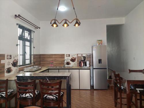 a kitchen with a table and a refrigerator at The Light Villa Flic en Flac LICENSED BY TOURISM AUTHORITY 16609 in Palmyre