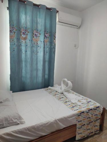 a bed in a room with a blue shower curtain at The Light Villa Flic en Flac LICENSED BY TOURISM AUTHORITY 16609 in Palmyre