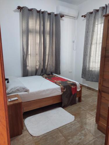 a bedroom with a bed and a window with curtains at The Light Villa Flic en Flac LICENSED BY TOURISM AUTHORITY 16609 in Palmyre